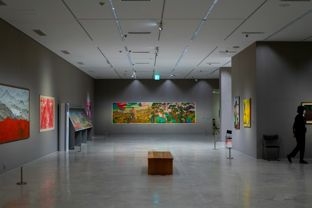 Art museum gallery with visitors viewing paintings